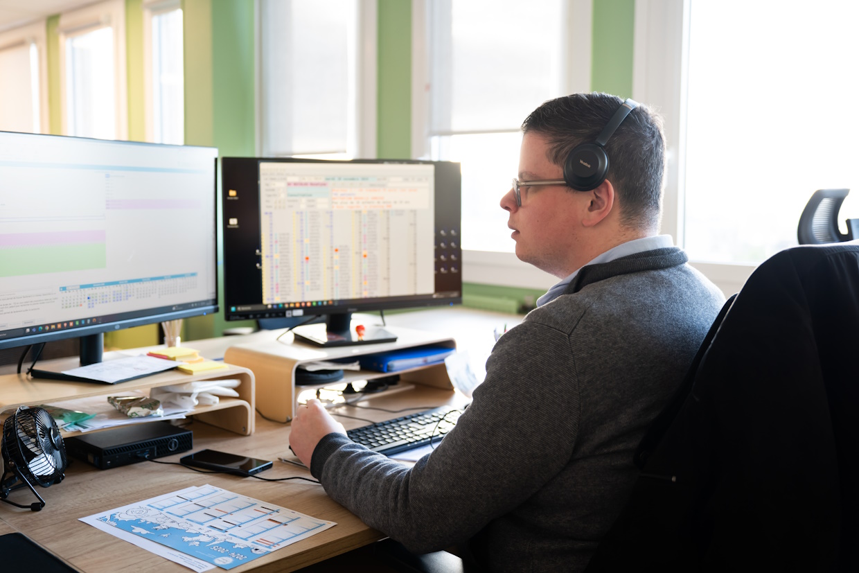 Homme travaillant sur ordinateurs de bureau.