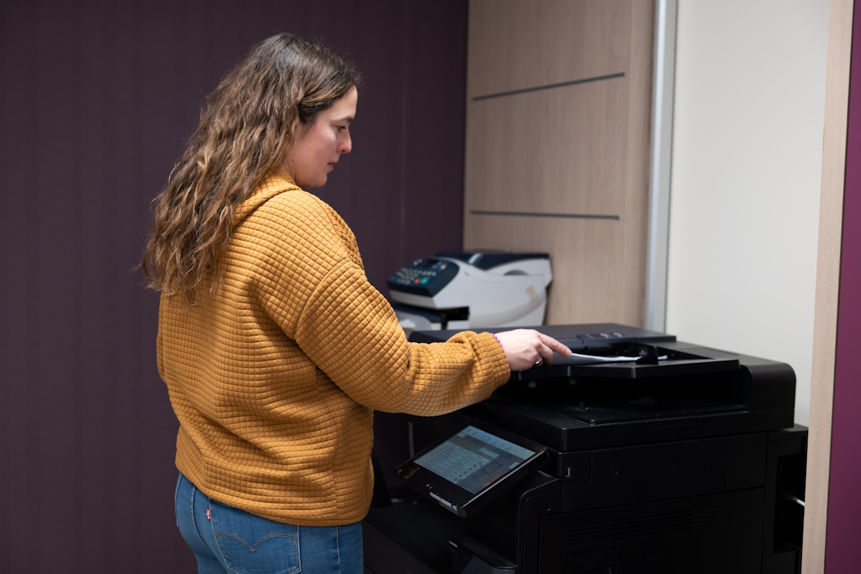 Femme utilisant une imprimante de bureau.